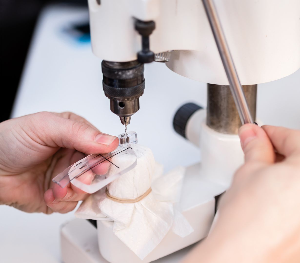 Mitarbeiter schleift ein Brillenglas in der Werkstatt von KreuzpunktOptik